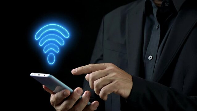 Businessman using smart phone with glowing neon line Wifi wireless internet network symbol icon. Wireless networking digital futuristic technology innovation concept. 4K Video motion graphic animation
