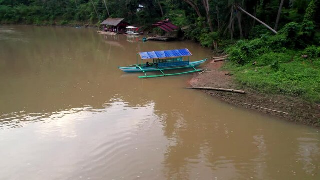 P&ecirc;cheur traditionnels philippins sur un bateau traditionnel sur une rivi&egrave;re marron au milieu de la jungle sauvage et des rochers sur l'ile de Bohol aux Philippines