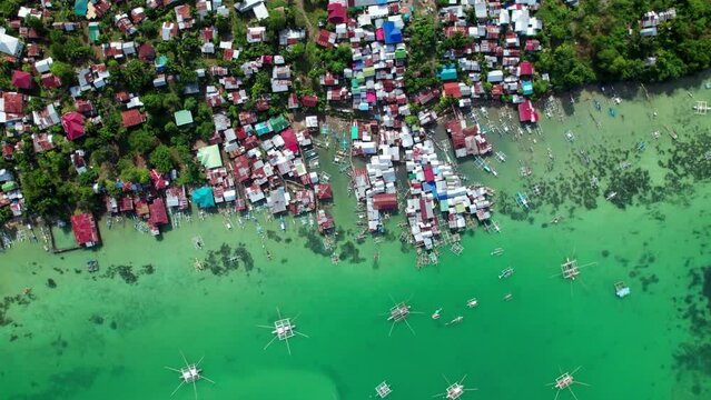Village de p&ecirc;cheurcolor&eacute; sur pilotis vu du ciel semblable &agrave; un bidonville au bord de la mer avec les bateau de p&ecirc;cheurs dans l'eau bleue sur l'ile de Panglao, &agrave; c&ocirc;t&eacute; de Bohol, aux Philippines, Asie