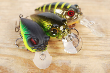 Three spinning lures on a wood texture background. Close-up.