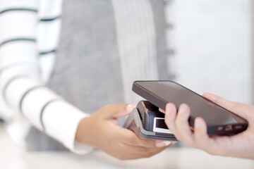 Customer using wireless digital payment on smartphone and credit card at the supermarket or grocery store.