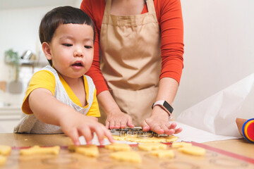 Asian Little boy and his Mother cutting on gingerbread dough with cutters. Cooking, Homemade.