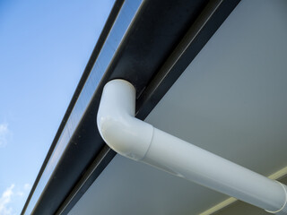 Downspout pipe, gutter elbow and house roof gutter channel connection.