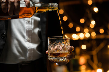 Businessman sitting and holding glass of whiskey