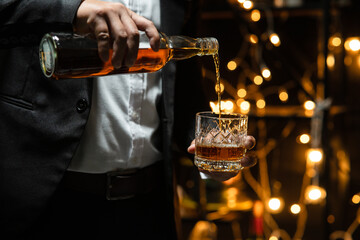 Businessman sitting and holding glass of whiskey