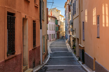 Narrow road between traditional old houses on a street near the local covered provencal farmers market in old town or Vieil Antibes, South of France