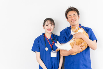 猫を抱く動物病院の男女の獣医師（アジア人）
