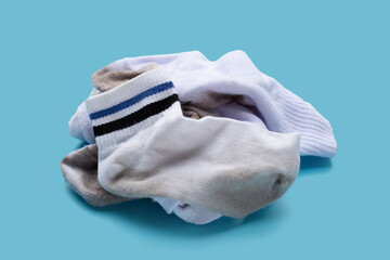 Dirty white socks on blue background. - obrazy, fototapety, plakaty