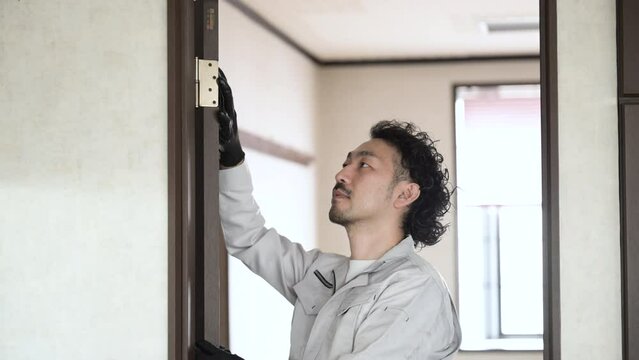 扉の蝶番の様子を確認や修理する作業員　内装業者などのイメージ
