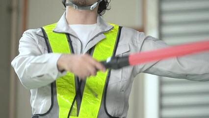 Faceless video of Japanese security guards and workers guiding in a warehouse with safety vests. no-face