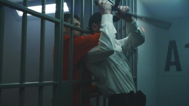 Male prisoner strangles jailer through metal bars, takes keys and opens prison cell. Criminal in orange uniform escapes from jail. Serving term for crime in detention center or correctional facility.