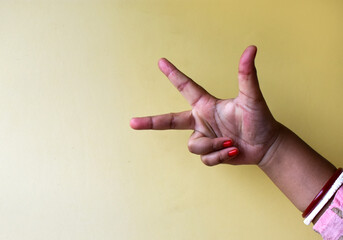 closeup of an Indian woman's hand showing three fingers of sign language isolated on clean...