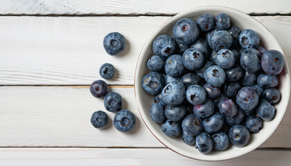 top view of fresh blueberries in bowl on white wooden table