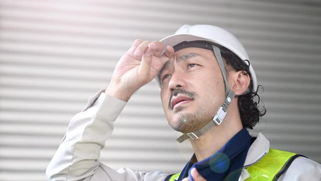 工事現場で働く作業員 作業着姿で汗をかく男性　熱中症予防もご安全にの動画