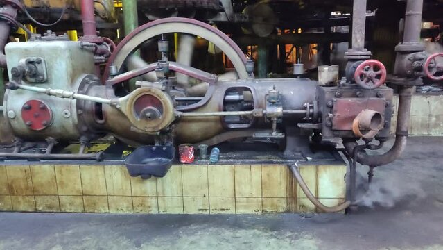 Steam engine driving an air compressor in a sugar industry factory.