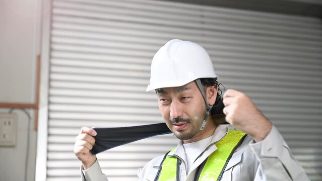 Workers at a construction site, man sweating in work clothes, video of Heat stroke prevention also be safe.　slow