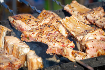 Shashlik of lamb ribs.. Grilled lamb ribs on a charcoal grill. Meat on skewers. Meat on the bone. Street food. Meat barbecue. Outdoor cooking