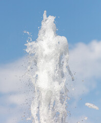 Fountain splashes against the blue sky. Background