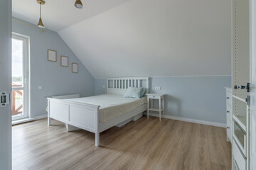 Modern bedroom in a new house in bright colors with a minimum amount of furniture