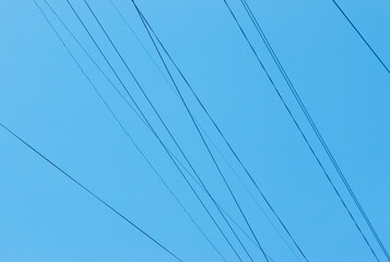 Electric wires against the blue sky