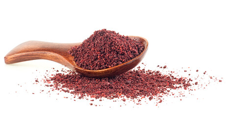 Ground sumac spice pile in wooden spoon isolated on a white background - obrazy, fototapety, plakaty