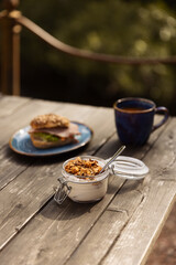 Breakfast with coffee standing on a wooden table outside.