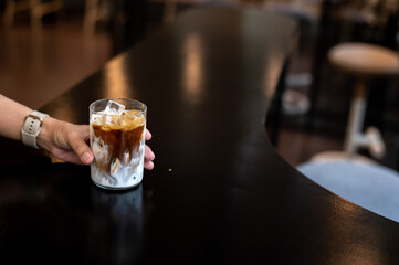 Iced coffee with milk in a glass on a table in a cafe