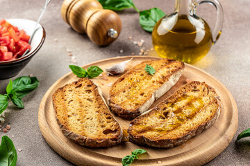 bread and olive oil ready to make toasts with tomatoes, basil, Concept healthy and balanced eating