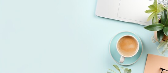 Photo of a cup of coffee next to a laptop on a desk with copy space with copy space