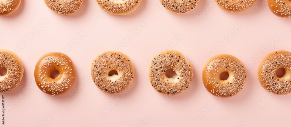 Poster photo of a colorful row of donuts on a vibrant pink background with copy space