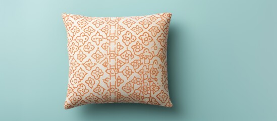 Photo of an orange and white pillow on a blue wall with plenty of copy space with copy space