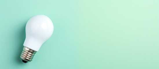 Photo of a white light bulb against a vibrant green and blue background with copy space