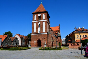 A view of an old medieval church or chapel made out of red brick and decorated with some white...