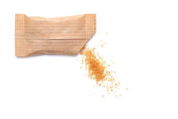 Spilled cane sugar from a small paper sachet. Preparation for sweetening beverages in a small package