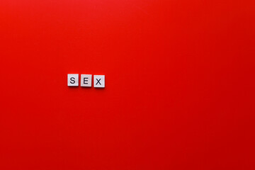 The word sex from wooden letters on a red background.