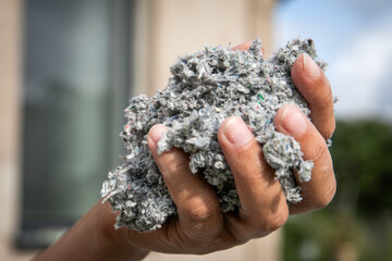 Cellulose insulation for walls and floors In hand. Recycled newsprint. Heat preservation and energy saving