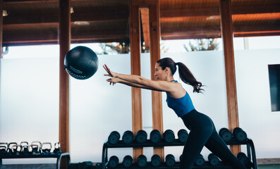 Chica joven entrenando en el gimnasio con entrenador