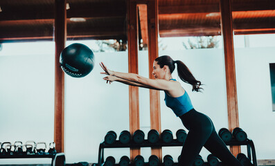 Chica joven entrenando en el gimnasio con entrenador