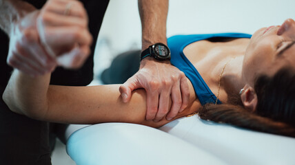 Foto detalle de fisioterapeuta tratando hombro a paciente - obrazy, fototapety, plakaty