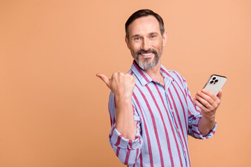 Photo of elderly man indicating empty space facebook twitter telegram instagram hold smartphone...