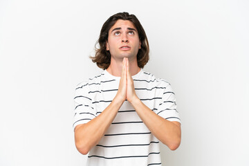 Young handsome man isolated on white background keeps palm together. Person asks for something