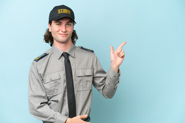 Young safeguard man isolated on blue background pointing finger to the side