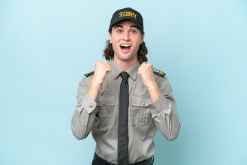 Young safeguard man isolated on blue background celebrating a victory in winner position