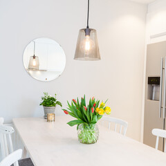 white kitchen table and chairs tulips in vase in stylish kitchen