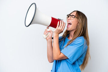 Young surgeon doctor woman isolated on blue background shouting through a megaphone