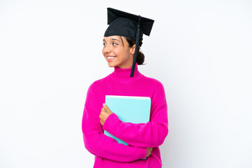 Young student hispanic woman holding a books isolated on white background looking side