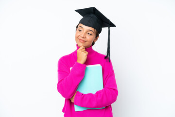 Young student hispanic woman holding a books isolated on white background looking up while smiling