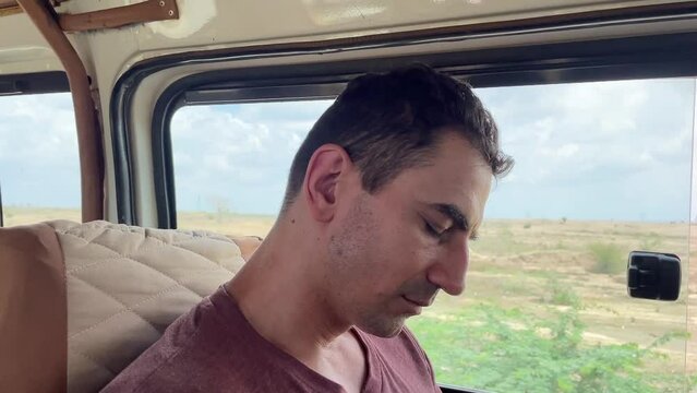 tired man tourist fall asleep in the car while travelling by jeep safari in africa