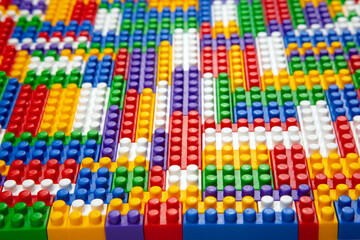 Abstract background texture of colored constructor blocks. Background of colorful plastic part of constructor. Pile of colored toy bricks.