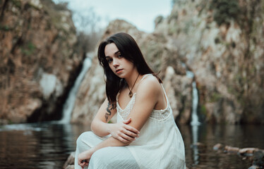 Joven modelo con vestido blanco posa dentro de un lago